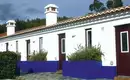 Unser Landhotel an der portugiesischen Küste Weißes Landhotel mit blauen Akzenten in Portugal, umgeben von Pflanzen.