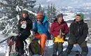 Jetzt haben wir uns eine Pause verdient! Gruppe bei einer Schneeschuhpause in verschneiter Winterlandschaft.