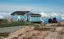 Einsames Haus in Grönland - aber die Aussicht... Blaues Haus mit Blick auf Eisberge und Meer in Grönland