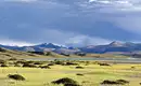Tibetische Hochebene mit Bergpanorama vor uns Grasbewachsene Steppe mit Bergen im Hintergrund in Tibet