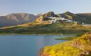 Blick auf Zahara de la Sierra mit See und Hügeln im Hintergrund.
