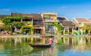 Idyllische Stadtansicht in Hoi An Fluss mit traditioneller Holzboot und bunten Häusern in Hoi An bei Sonnenschein.