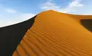 Sanddüne in der Sahara Große Sanddüne in der Sahara mit wellenartiger Struktur und blauem Himmel im Hintergrund.