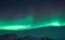 Polarlichter über den Lofoten Nordlichter leuchten über schneebedeckten Bergen in den Lofoten.