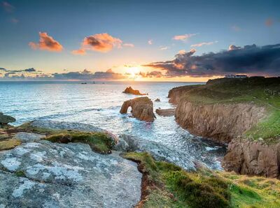 Wenn die Sonne im Atlantik versinkt: Küstenwandern in Südengland zwischen schroffen Felsen und weitem Meer.