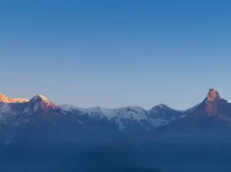 Berggipfel im Himalaya im Morgenlicht vor klarem blauen Himmel.