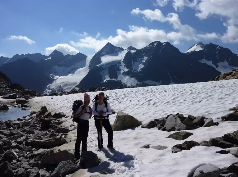 Bergsteiger in den Stubaier Alpen vor schneebedeckten Gipfeln.