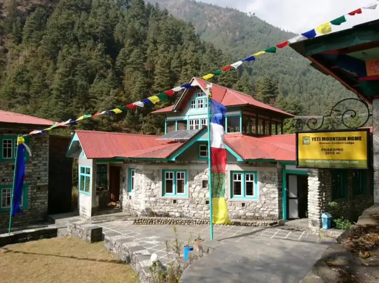Ein traditionelles Gasthaus im Himalaya mit bunten Gebetsfahnen.