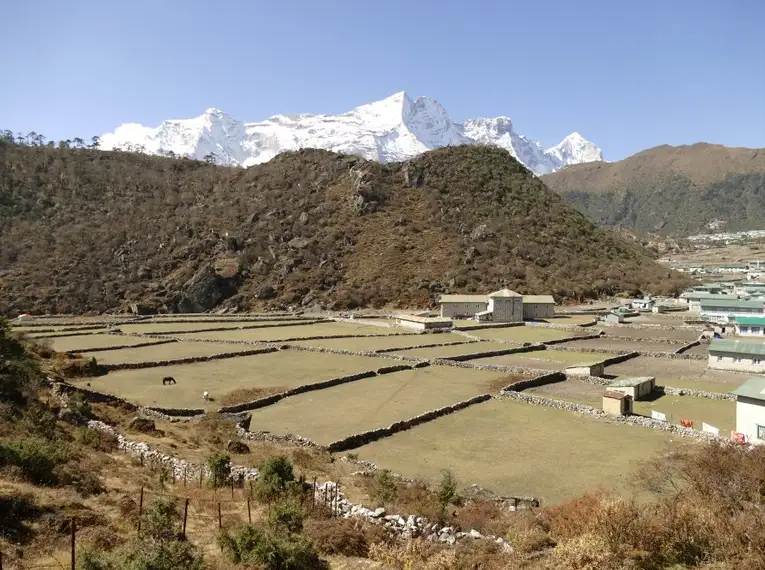 Panorama von schneebedeckten Bergen und grünen Tälern in Nepal.