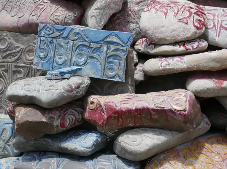 Pilgersteine in Tibet mit farbigen Gebetsinschriften aufeinander gestapelt.