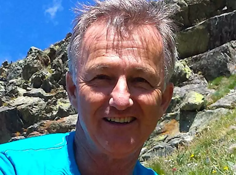 Unser Wanderführer Norbert Berger in den Japanischen Alpen Porträt eines lächelnden Mannes vor felsiger Bergkulisse.