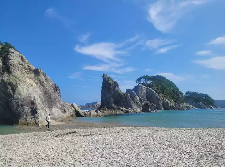Felsküste am Michinoku Coastal Trail entdecken Dramatische Felsformationen entlang des Michinoku Coastal Trail in Japan mit blauem Himmel und klarem Wasser.