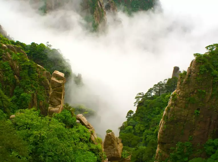 Mystische Landschaft in Chinas Bergregionen Dichte Wolken ziehen durch die schroffen Berge Chinas.