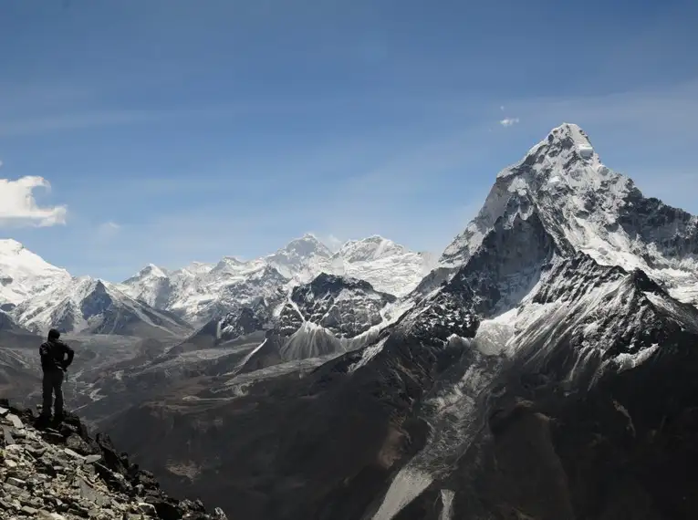 Ein Wanderer steht vor der beeindruckenden Himalaya-Berglandschaft.