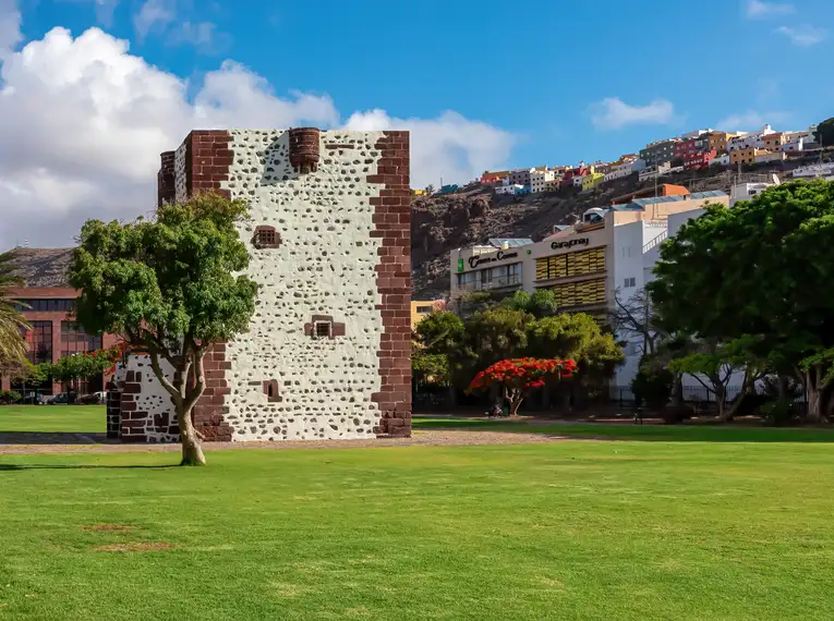 Historischer Steinturm auf grüner Wiese bei San Sebastián, La Gomera.