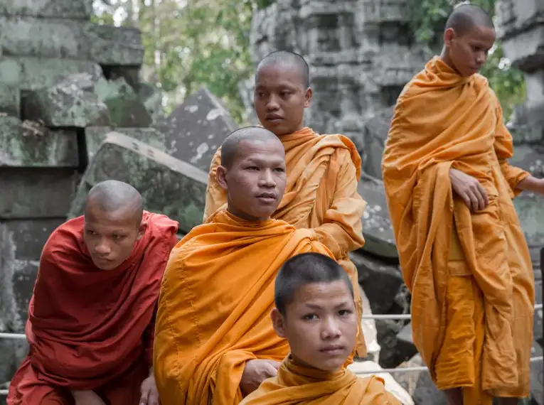 Gruppe buddhistischer Mönche in orangen Roben bei Angkor Wat