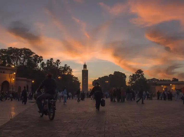 Abenddämmerung in Marrakech Menschen auf einem Platz in Marrakech bei Sonnenuntergang.