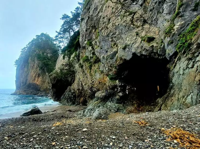 Felsen entlang des Michinoku Coastal Trail Steiler Küstenfelsen am Michinoku Coastal Trail in Japan, umgeben von Meer und Kieselstrand.