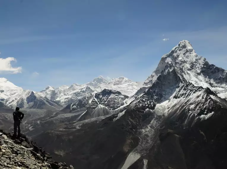 Ein Wanderer steht vor der beeindruckenden Himalaya-Berglandschaft.