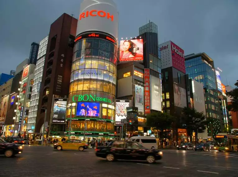 Beeindruckende Stadtansicht von Tokio bei Nacht Geschäftige Straßenszene mit beleuchteten Hochhäusern in einer Stadt bei Nacht.
