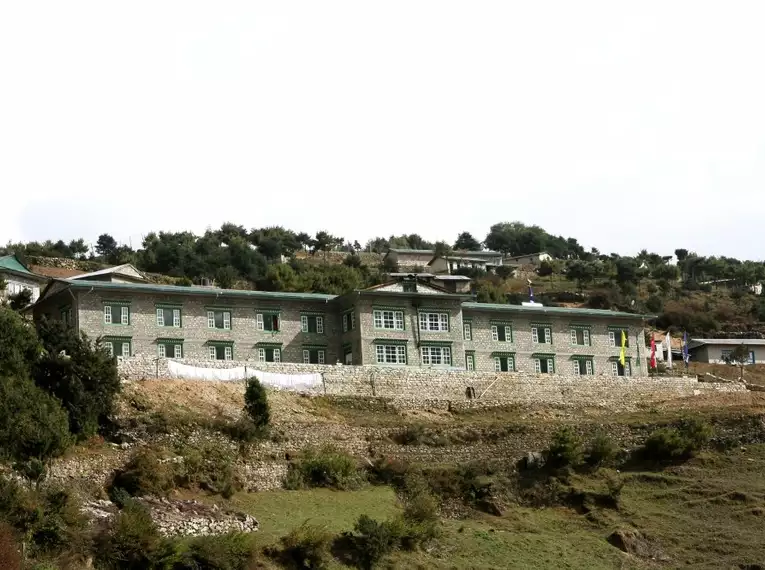 Steinlodge in bergiger nepalesischer Umgebung mit Fahnen