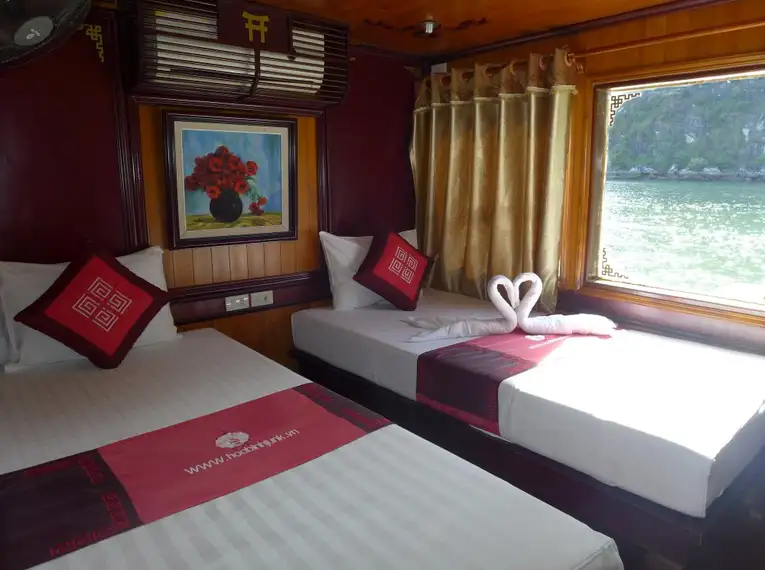 Gemütliche Kabine auf einer traditionellen Dschunke in der Halong-Bucht mit Blick aufs Wasser.