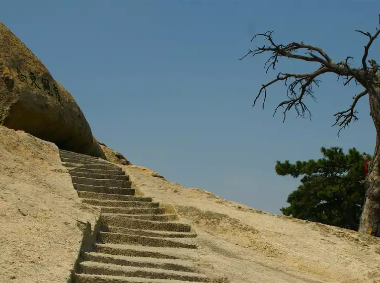 Wanderpfad über viele Stufen in Chinas Berglandschaft Steinpfad für Wanderer vor karger Baumlandschaft in China.