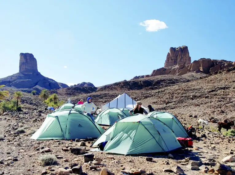 Trekking im Saghro-Gebirge Gruppe von Zelten in der felsigen Landschaft des Saghro-Gebirges mit Felsformationen im Hintergrund.