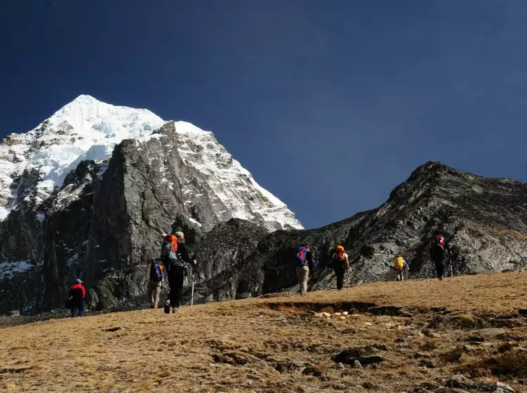 Gruppe von Wanderern in der Himalaya-Berglandschaft unter klarem Himmel.