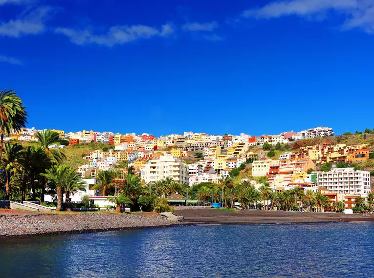 Bunte Küstenstadt auf La Gomera Hübsche Küstenstadt auf La Gomera mit bunten Häusern und Palmen.