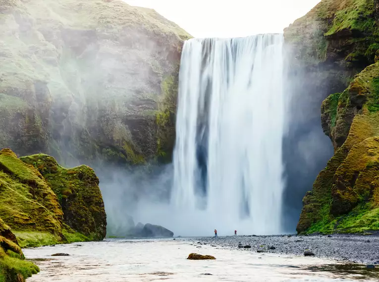 Majestätischer Wasserfall auf Island Ein beeindruckender Wasserfall in einer grünen Landschaft in Island.