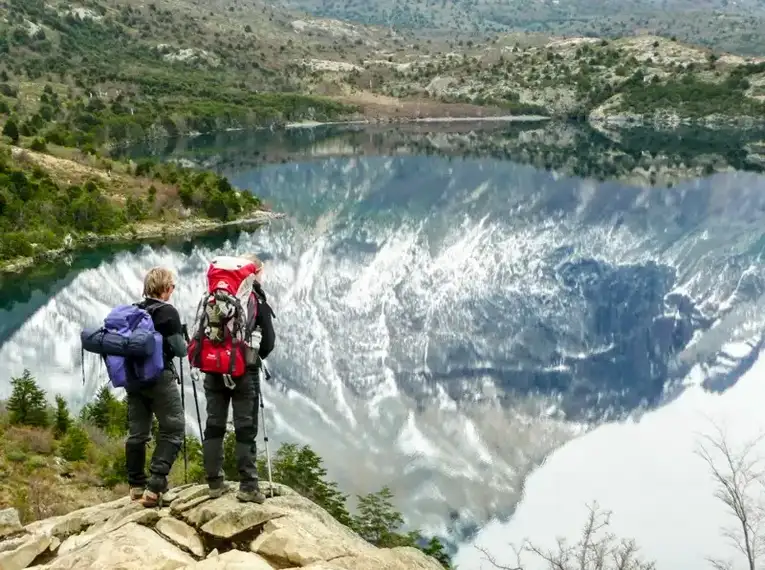 Zwei Wanderer in Patagonien betrachten malerischen See.