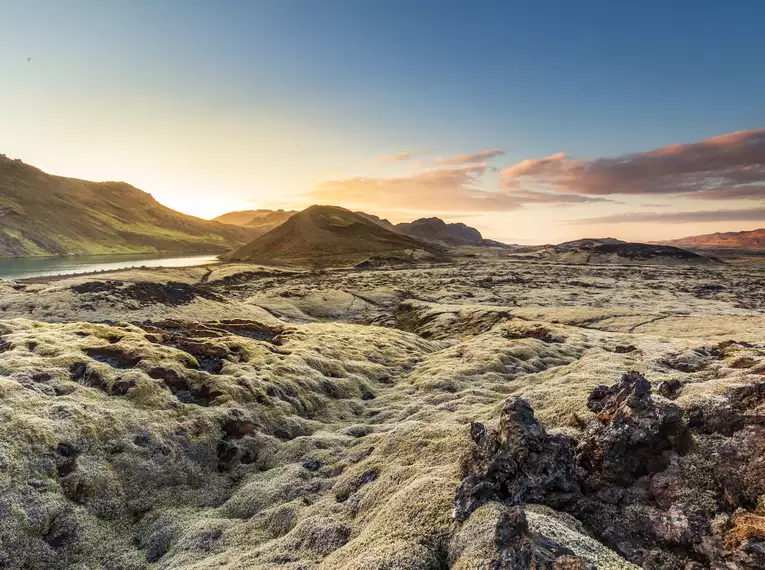 Atemberaubende isländische Landschaft Sonnenuntergang über einer moosbedeckten Vulkanlandschaft in Island.