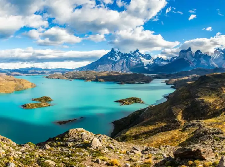 Panorama des Torres del Paine Nationalparks Panoramablick über den Torres del Paine Nationalpark mit Bergen und Seen unter einem wolkigen Himmel.