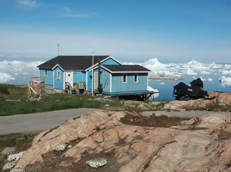 Einsames Haus in Grönland - aber die Aussicht... Blaues Haus mit Blick auf Eisberge und Meer in Grönland