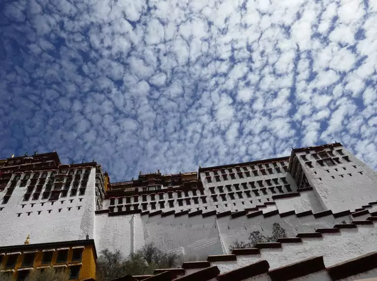 Blick auf den Potala-Palast in Lhasa mit imposantem Wolkenhimmel.