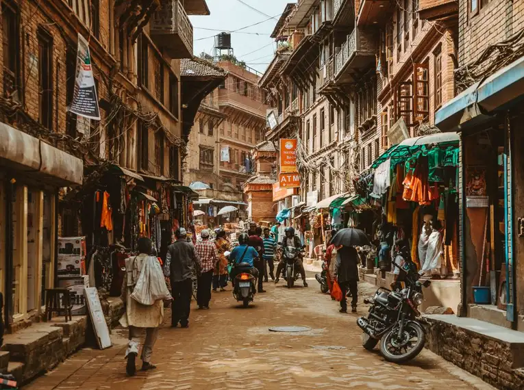 Eine belebte Straße in Bhaktapur mit historischen Gebäuden und Geschäften.