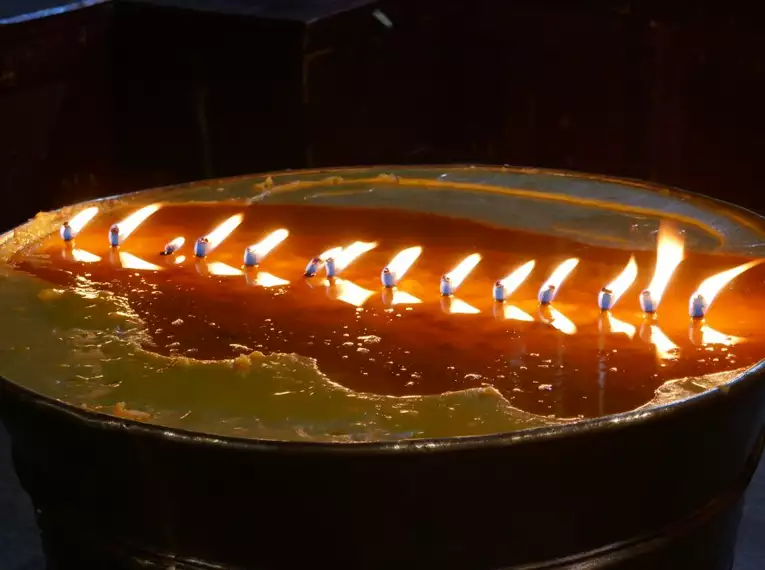 Mehrere brennende Butterlampen in einem tibetischen Kloster.