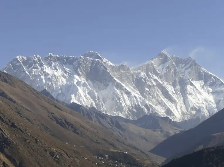 Blick auf schneebedeckte Gipfel im Himalaya und grünes Tal.