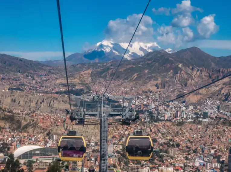 Seilbahn über der Stadt La Paz, umgeben von Bergen und klarer blauer Himmel.