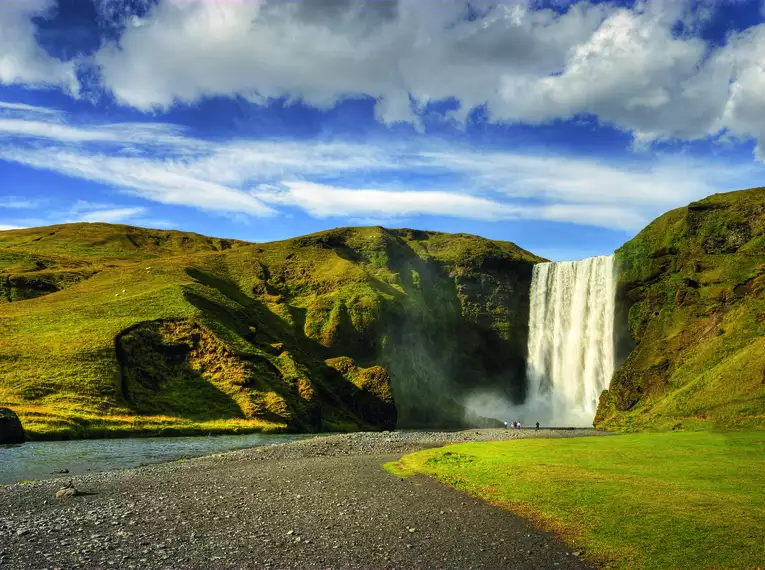 Beeindruckender Wasserfall auf Island Reisende genießen die Aussicht auf einen großen Wasserfall in Island.