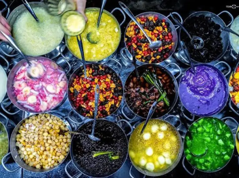 Bunte vietnamesische Desserts in Schalen auf einem Markt.
